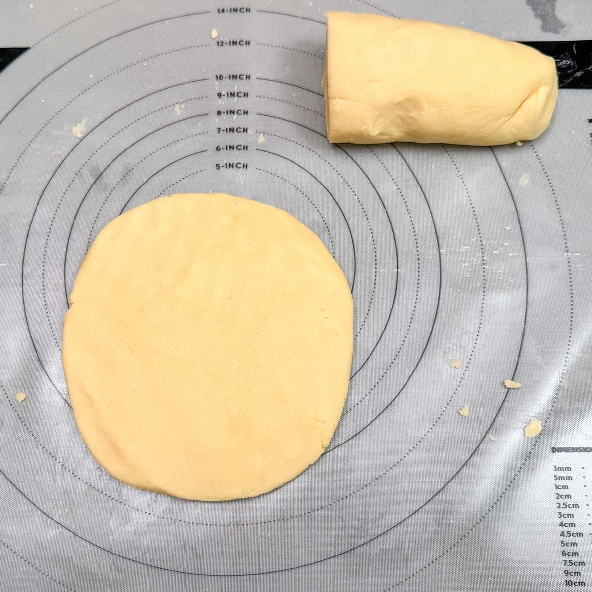 Honey almond cookie dough log that has been cut in half and flattened into a disk to be chilled.