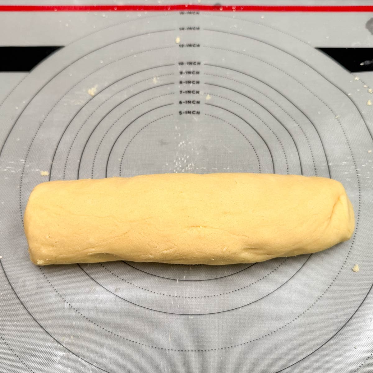 Honey almond dookie dough that has been kneaded into a log shape.