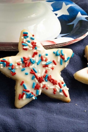 Honey almond glazed cookies leaning against a plate that is for 4th of July.