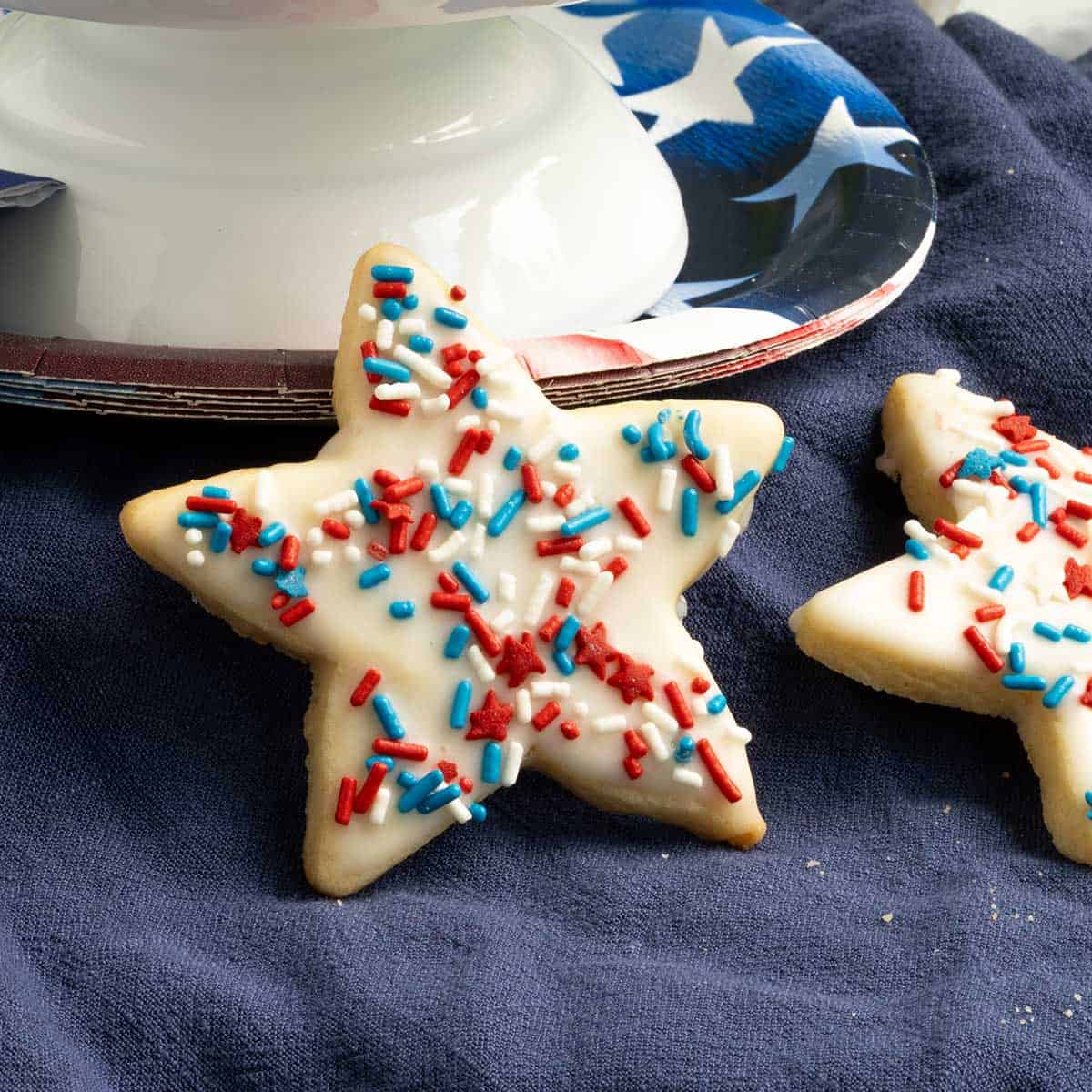 Honey almond glazed cookies leaning against a plate that is for 4th of July.