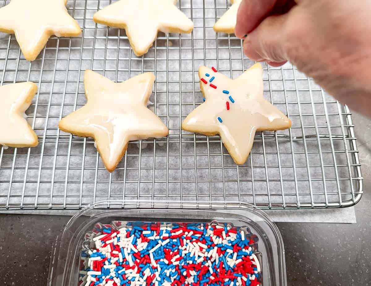Adding jimmies to the honey almond glazed cookies.