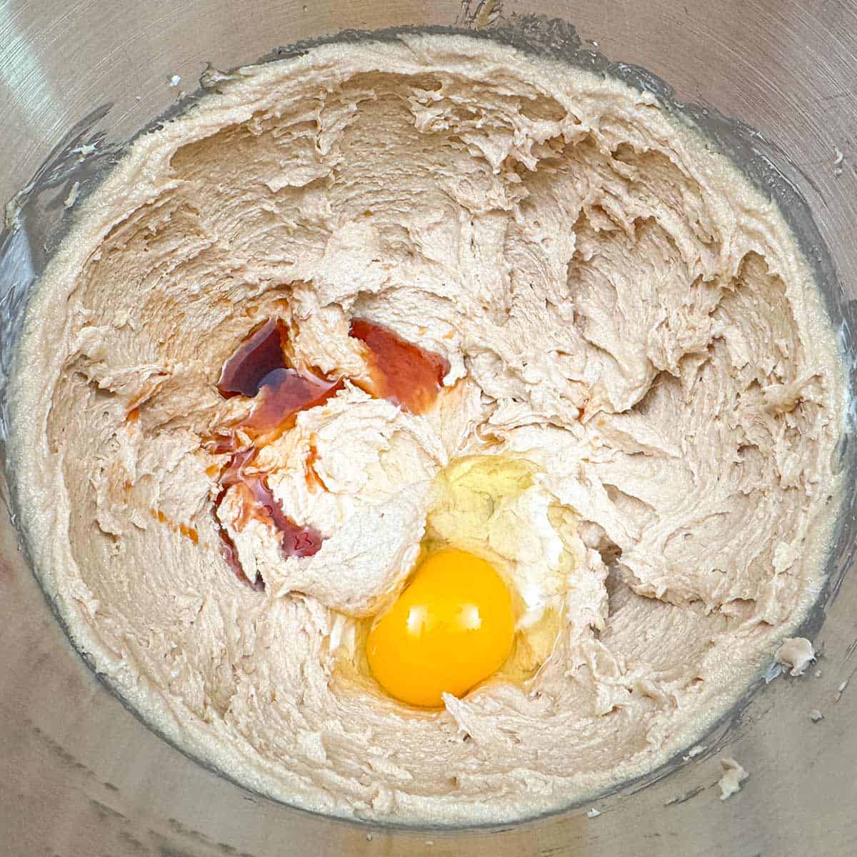Adding the egg and vanilla extract to the butter-cream cheese, peanut butter, and sugar mixture.