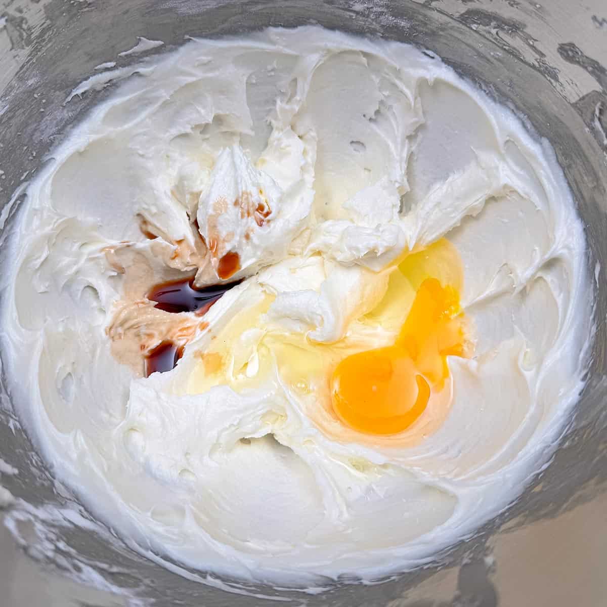 Adding the vanilla extract and egg to the butter-sugar mixture.