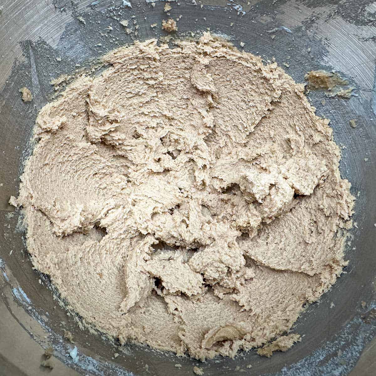 Mixing brown and white sugars to the creamed butter in a mixer bowl.