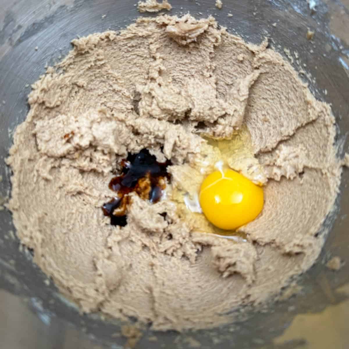 Adding the egg and the vanilla extract to the sugar-butter mixture.