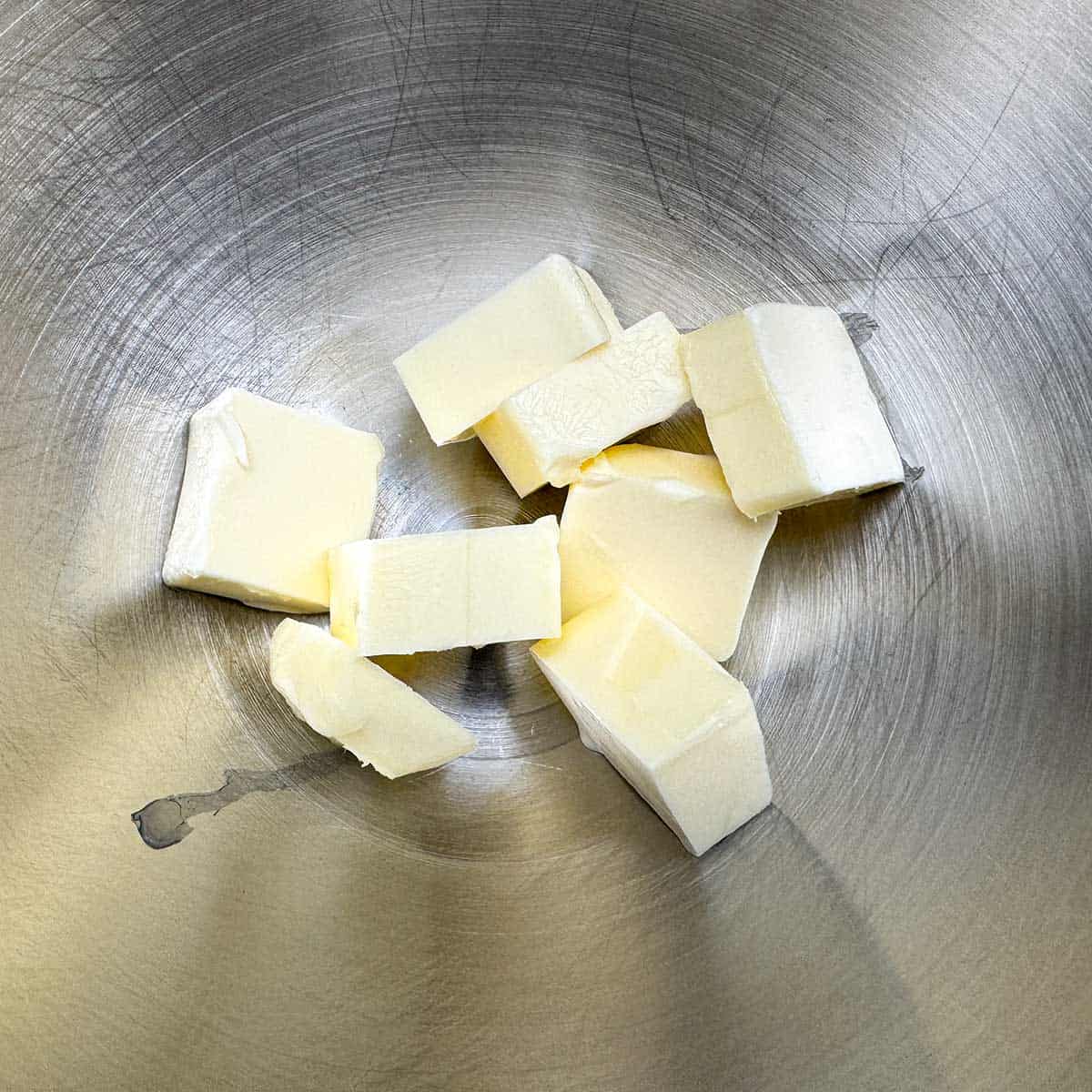 Cubed butter that will be creamed in a mixer bowl.