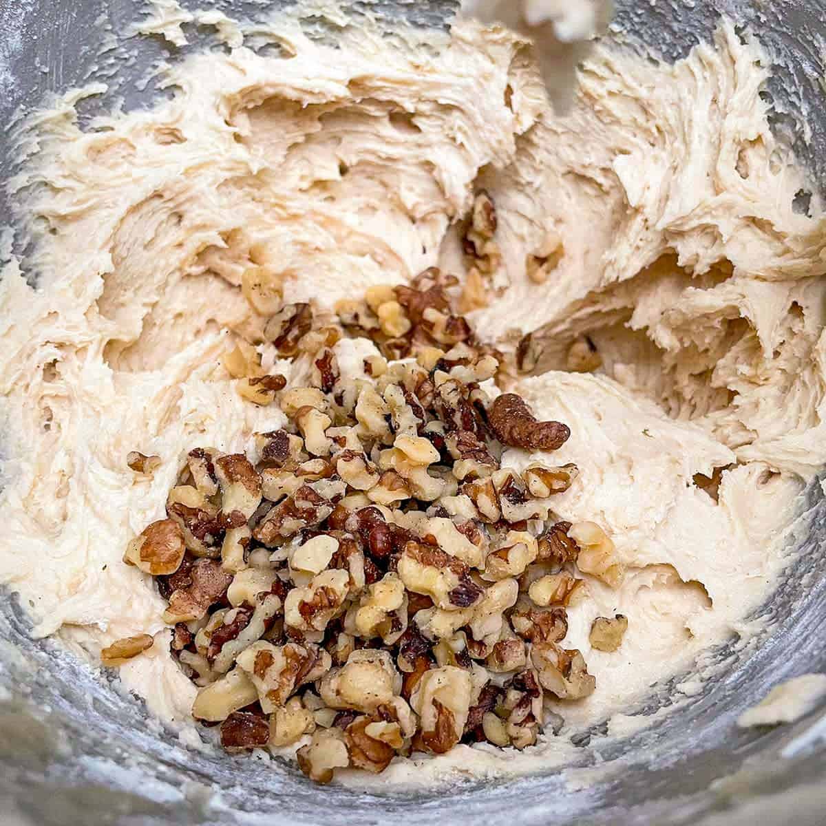 Adding the chopped walnuts to the cookie dough.