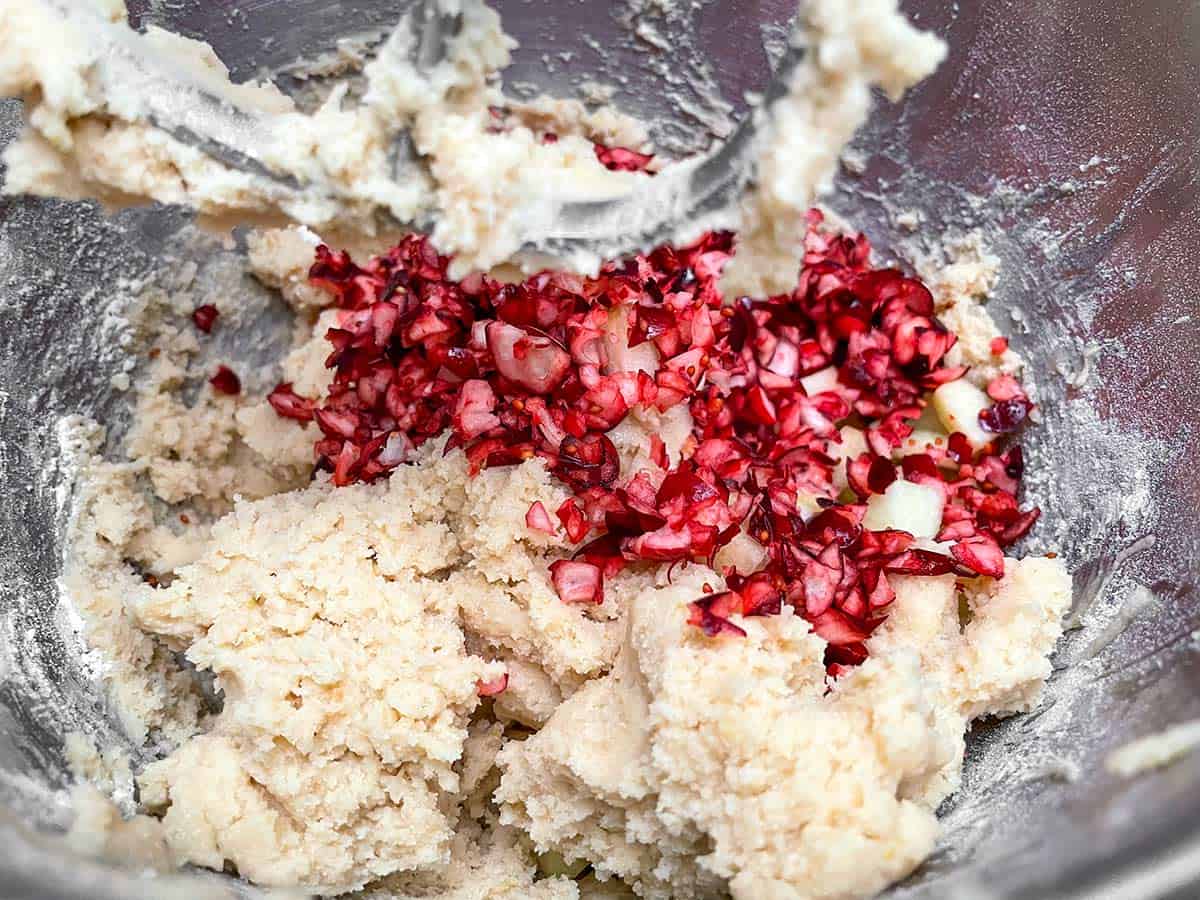 The dry ingredients have been added and mixed now it is time to add the cranberries and apples.