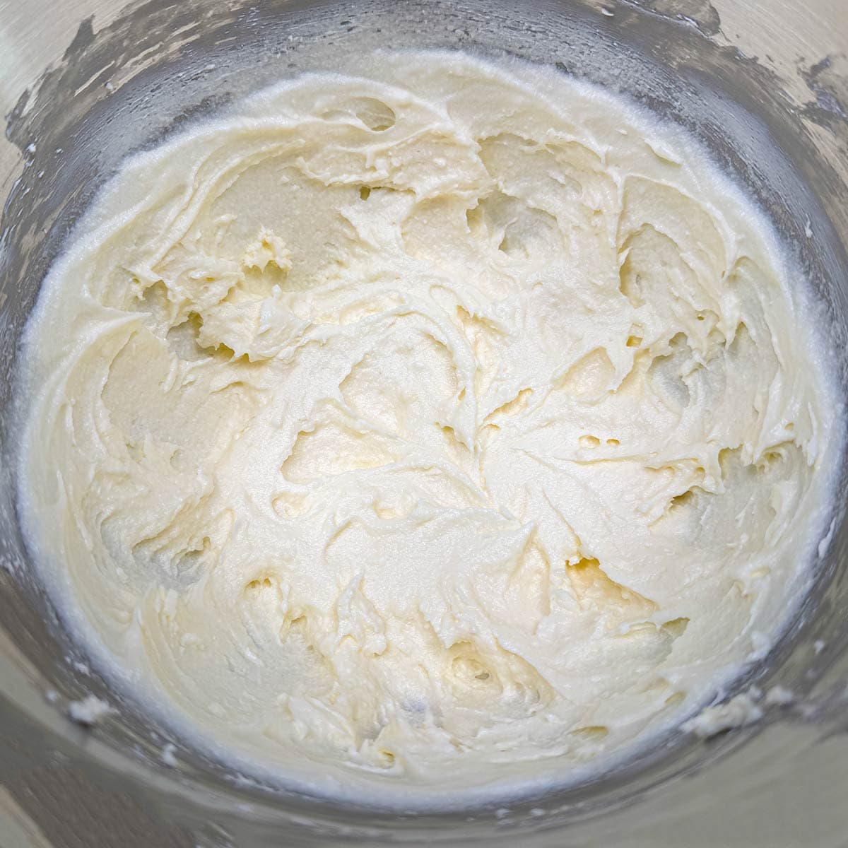 Cream cheese, butter, and sugar mixed until smooth and creamy in a mixer bowl.