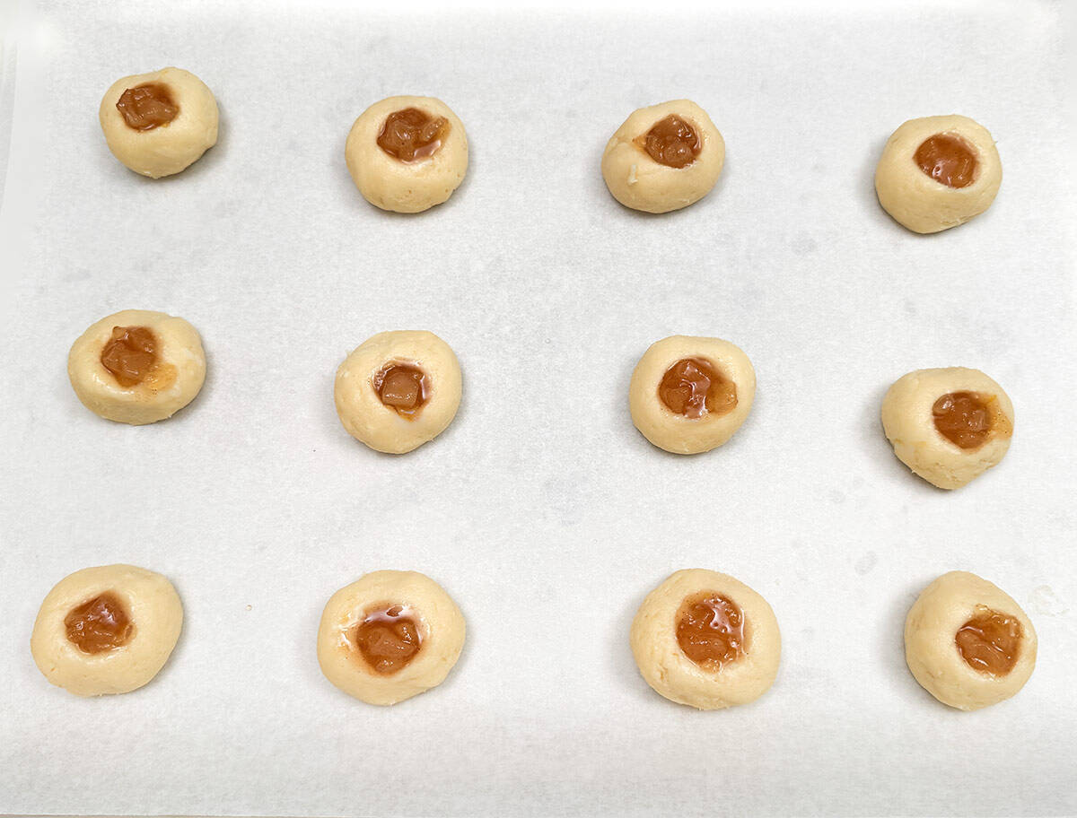 The pear filling has been spooned into the wells in the cookie balls.