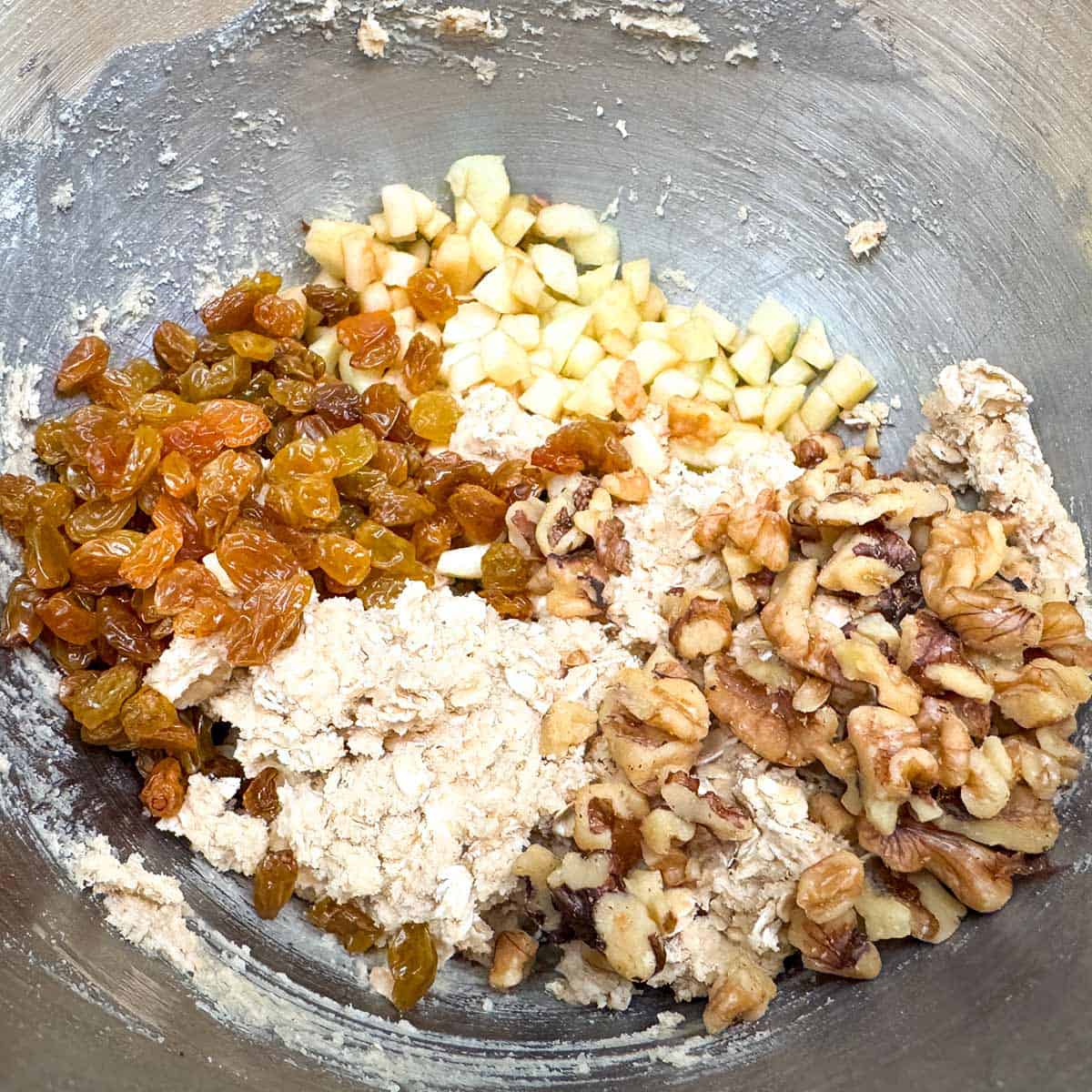 Adding to the cookie dough the golden raisins, chopped walnuts, and the diced apple.