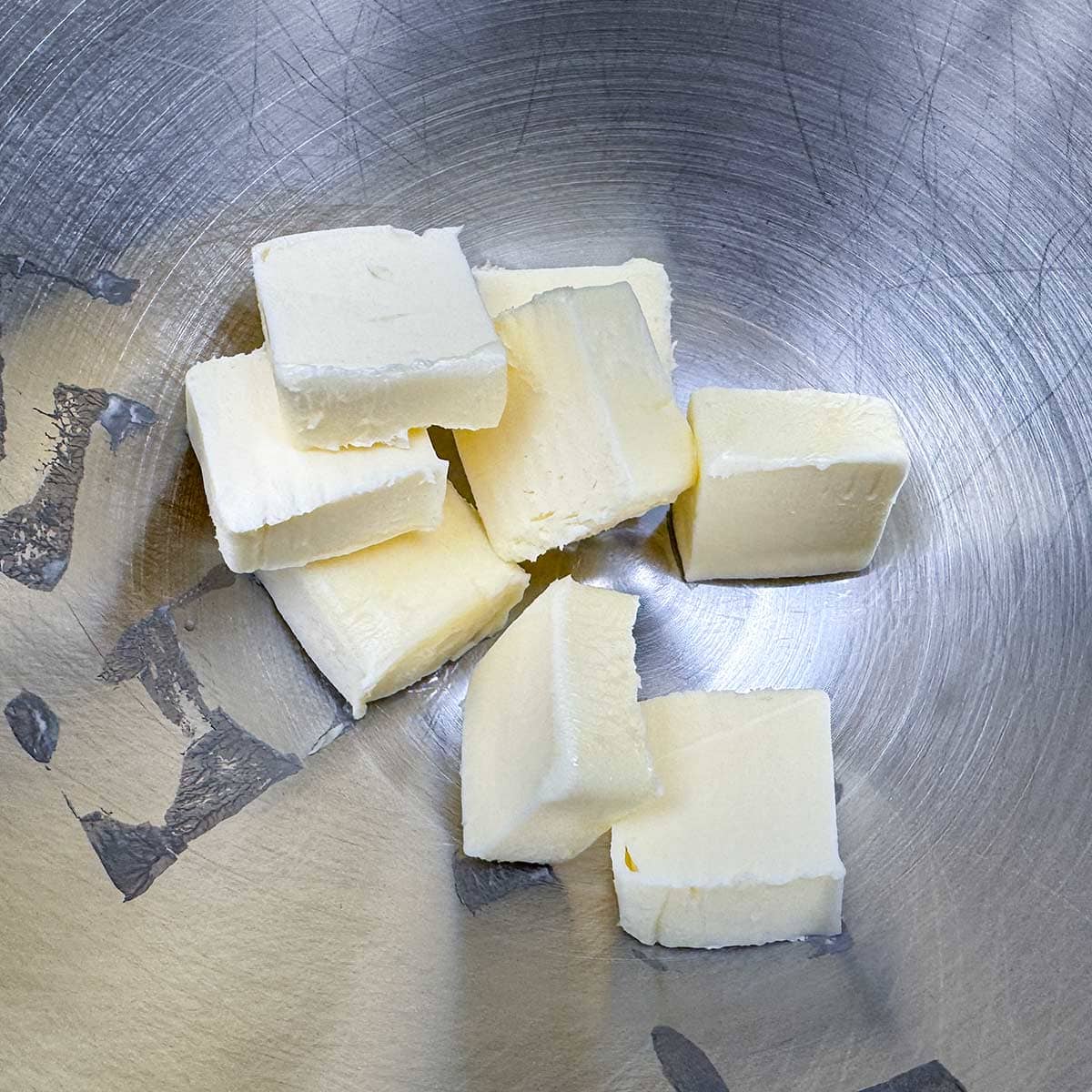 Cubed butter in a mixer bowl.