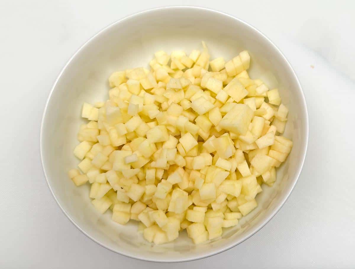 A diced Granny Smith apple in a bowl.