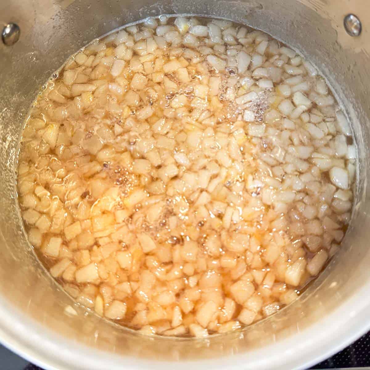 Turning the burner down so the pear filling comes to a low boil in the saucepan.