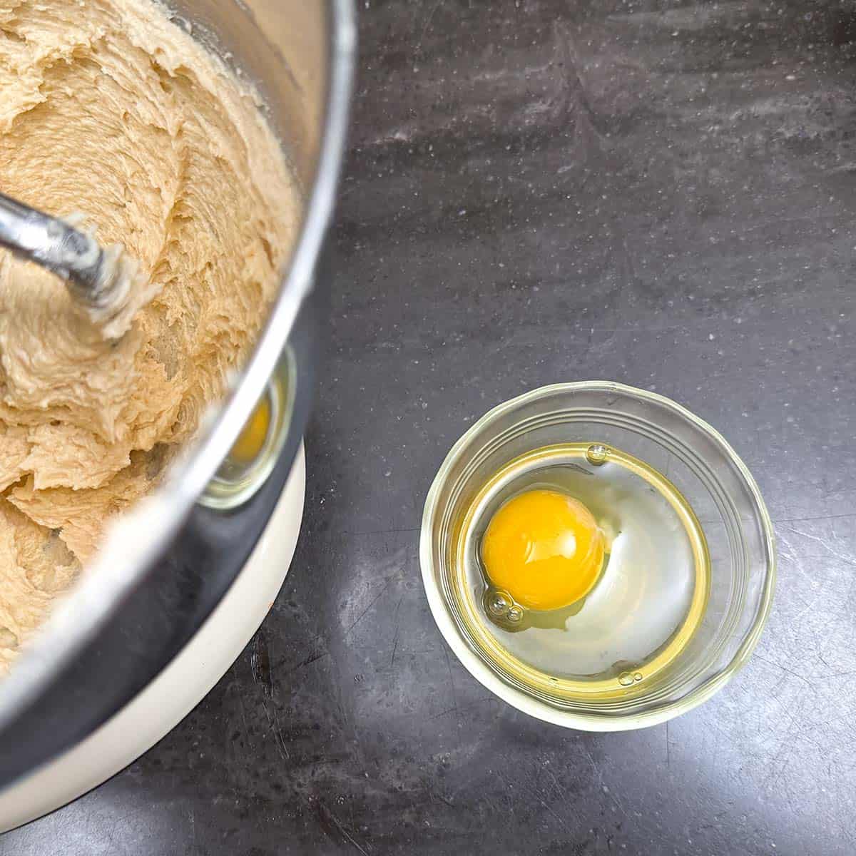 An egg in a small cup to check for shells before adding to the cookie dough.