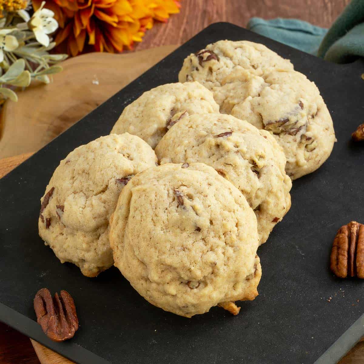 Maple butter pecan cookies on a cutting board with 6 cookies - feature.