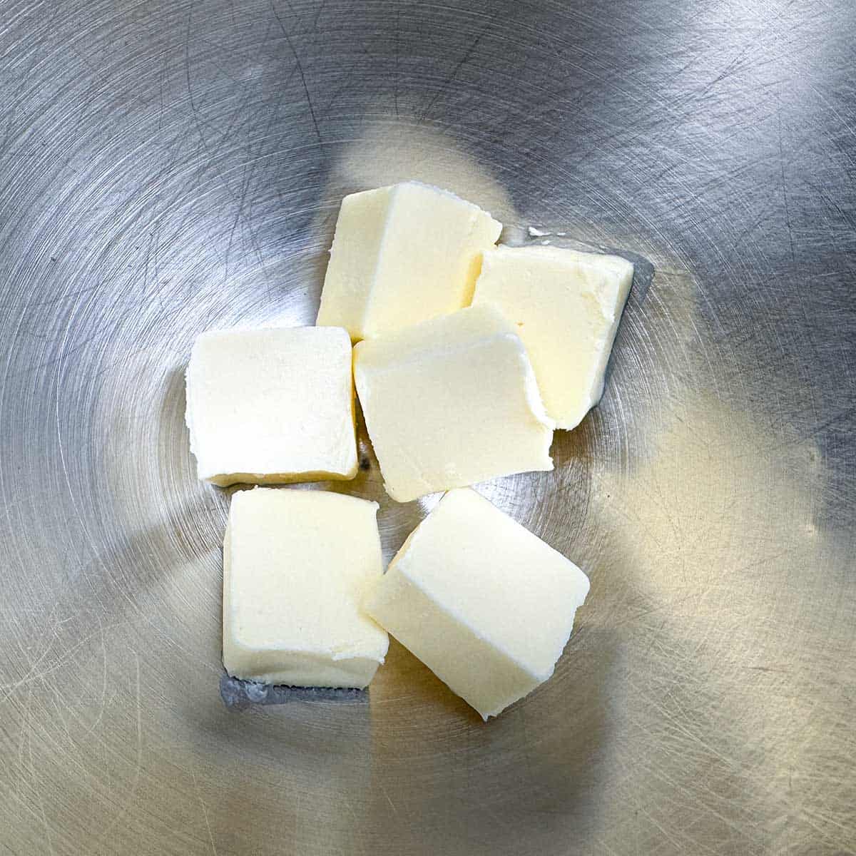 Cubed butter in a mixer bowl.